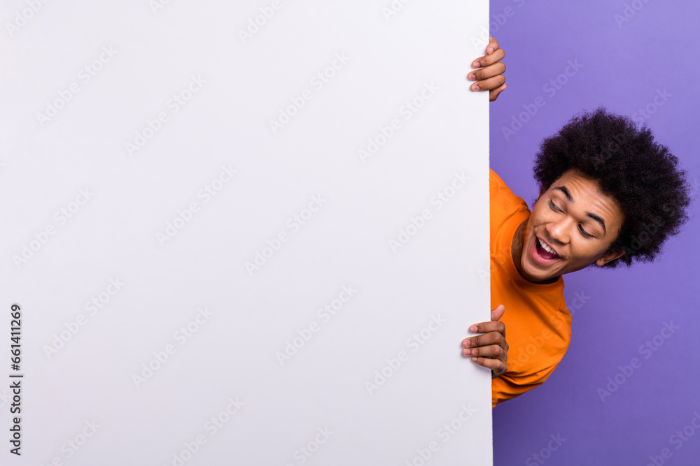 Photo surprised reaction unbelievable news watching guy looking empty space whiteboard hiding youngster isolated on violet color background Photo surprised reaction unbelievable news watching guy looking empty space whiteboard hiding youngster isolated on violet color background