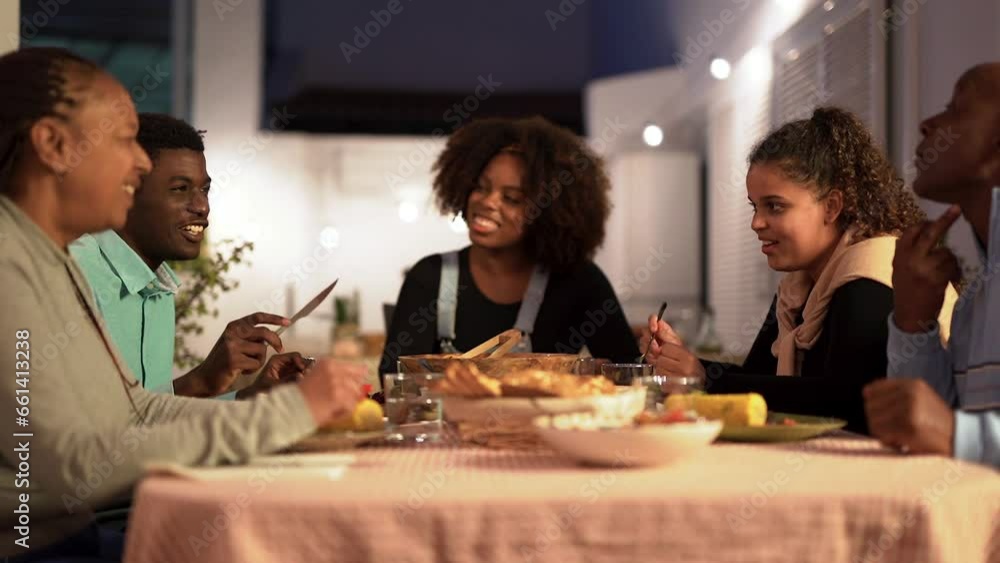 Happy african family eating dinner together at home terrace - Party, bonding and holiday concept