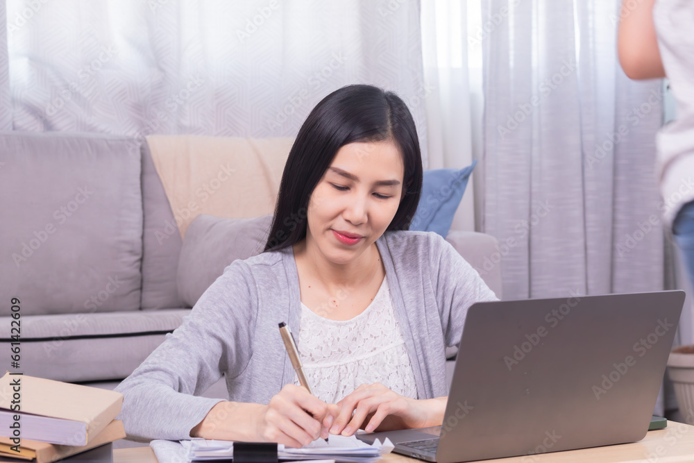 Asian happy female working at home calculate bookkeeping for tax declarations using modern technology laptop, well-organized planning financial payment for housing loan, women working paperwork bills Asian happy female working at home calculate bookkeeping for tax declarations using modern technology laptop, well-organized planning financial payment for housing loan, women working paperwork bills