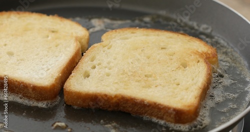 The bread is fried in butter or oil in a frying pan. Making croutons. Cooking food. Preparing breakfast. Close-up.