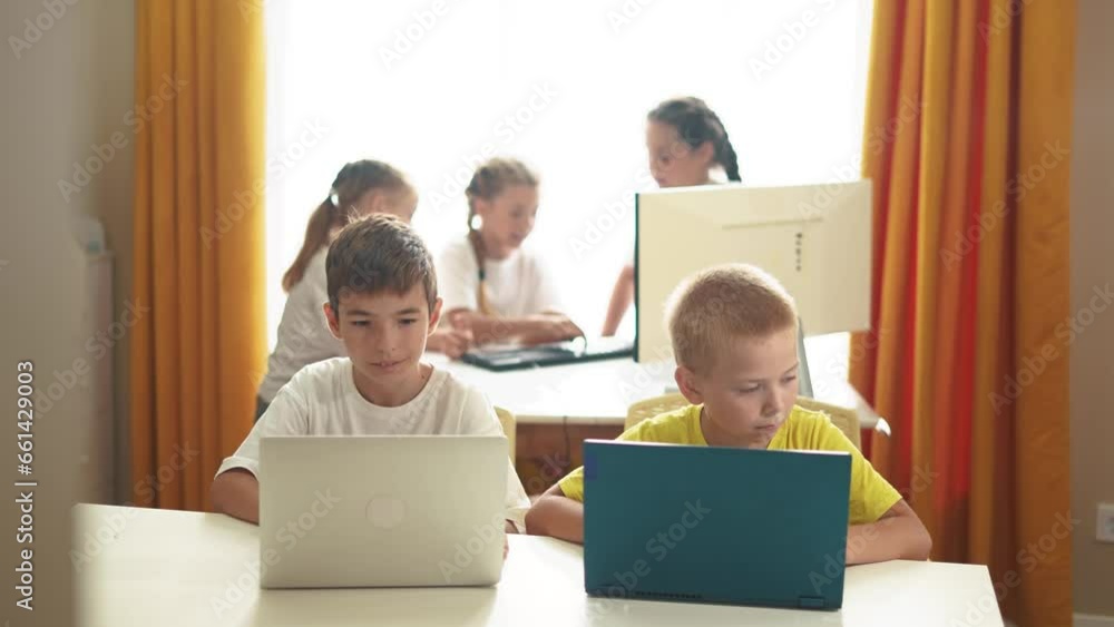 group of children study at home via lifestyle laptops. business concept of modern training and development. little kids are educated through the computer. two boys with laptops in the foreground group of children study at home via lifestyle laptops. business concept of modern training and development. little kids are educated through the computer. two boys with laptops in the foreground