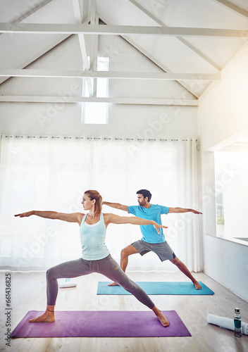 Couple, yoga and stretching in studio workout, exercise and holistic training with balance, pilates or fitness. People or personal trainer in warrior pose for wellness, health and learning together