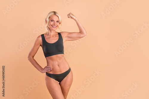 Full length photo of attractive sportive woman showing nice body loss weight fitness empty space isolated on beige color background