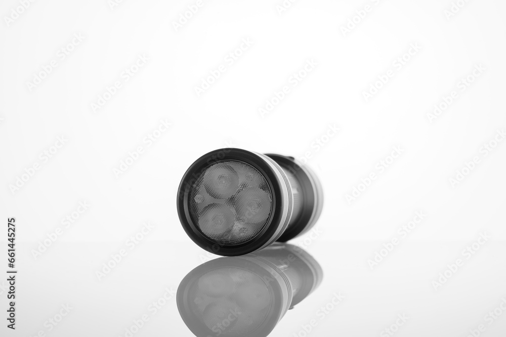 black LED modern handheld flashlight on a white background with reflection, metal durable housing, double-sided, led flashlight, reflexed pen, studio photo black LED modern handheld flashlight on a white background with reflection, metal durable housing, double-sided, led flashlight, reflexed pen, studio photo