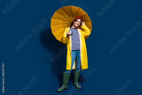Full body photo of nice girlfriend posing model careless hold yellow parasol rainstorm wet weather isolated on blue color background photo