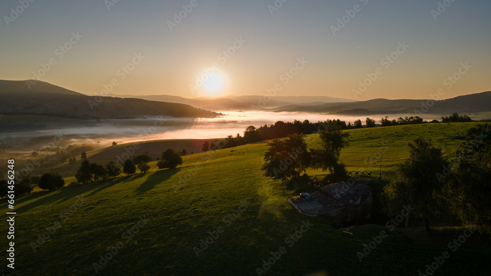 Beautiful scenery of sunrise in czech mountains with meadows, forest and concrete bunker