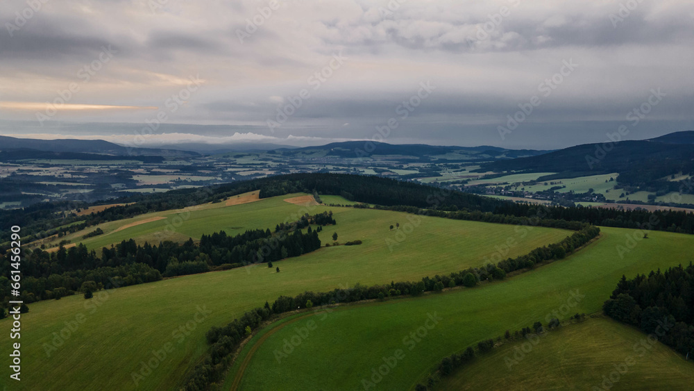 Aerial view of Orlicke hory with meadows and forests during cloudy day.