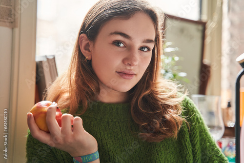 Portrait of the teen woman sitting at the kitchen and looking at the camera