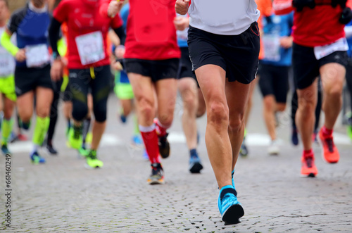 legs of people running during the marathon in the city streets
