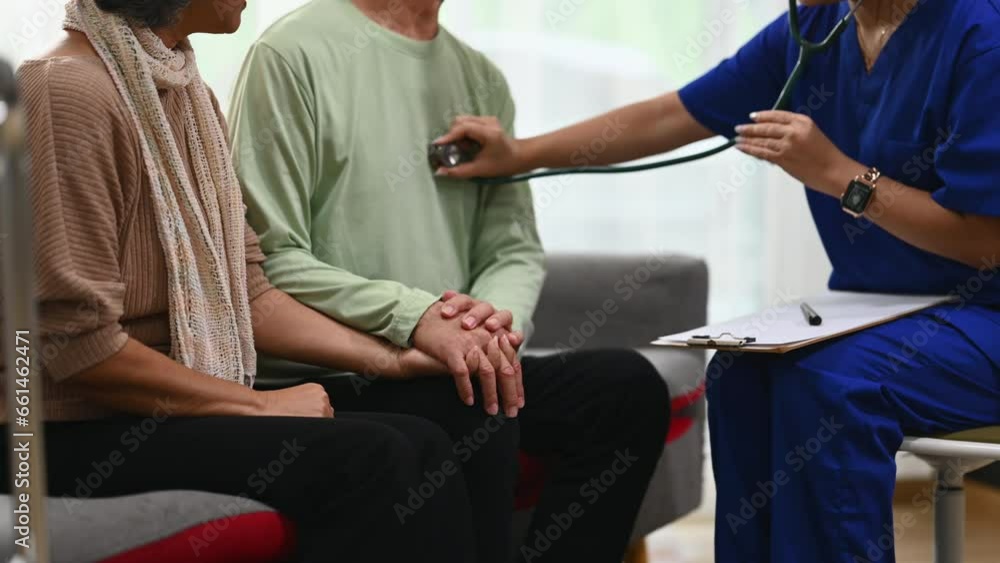 Female doctor using stethoscope examining senior male during home care visit. Elderly healthcare concept Female doctor using stethoscope examining senior male during home care visit. Elderly healthcare concept
