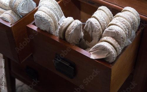 Wooden drawer full of white espadrille shoes photo