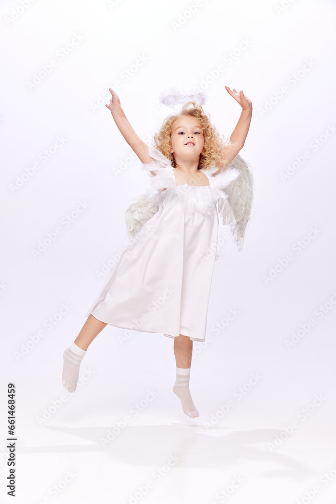 Happy, adorable, cute baby girl child in image f angel dancing and handing fun isolated over white studio background. Concept of childhood, imagination, fantasy, fashion and beauty, holidays Happy, adorable, cute baby girl child in image f angel dancing and handing fun isolated over white studio background. Concept of childhood, imagination, fantasy, fashion and beauty, holidays
