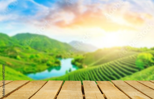 Wooden table top on blur green tea mountain and grass field.Fresh and Relax concept.For montage product display or design key visual layout.View of copy space.