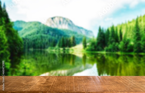 Wooden table top on blur green forest and lake or swamp.Fresh and Relax concept.For montage product display or design key visual layout.View of copy space.