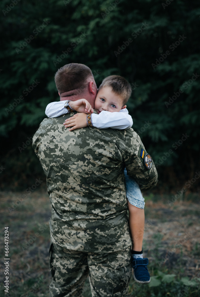 A little boy met a soldier. The son hugs the father of the Ukrainian soldier. The Ukrainian defender returned home to his family. Mobilization of Ukrainian men. War in Ukraine