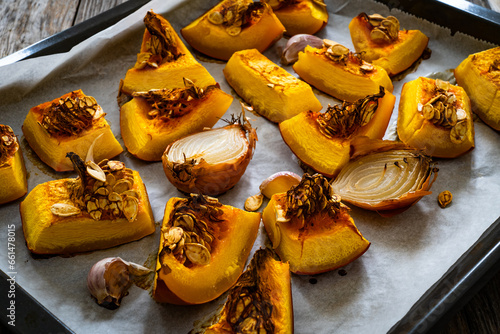 Roasted pumpkin with onion and garlic on wooden table 