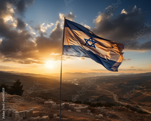 Israel flag on a flagpole on a hill against the background of dawn