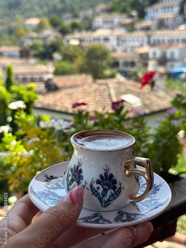 turkish coffee in a traditional porcelain mug and cute village at the background