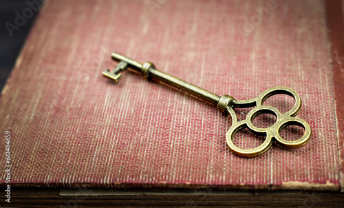 Key on an old book. Top secret, confidential or classified background.