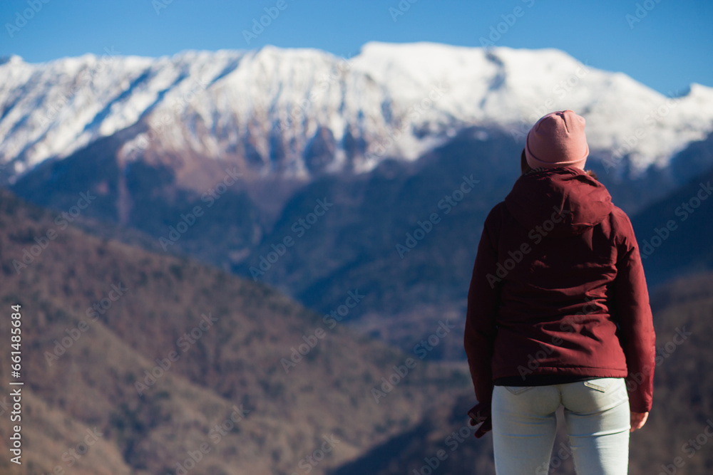 A young woman admires the mountain views in winter