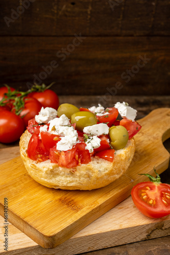Greek dish dakos with tomatoes and olives, vertical photo.