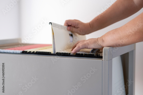 Tableau sur toile female archivist hands through folders In Document Storage, Home Archive, Record