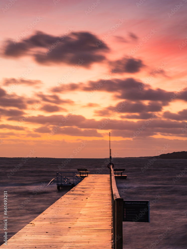 Tranquil Sunset on Beach Pier with Ocean Horizon