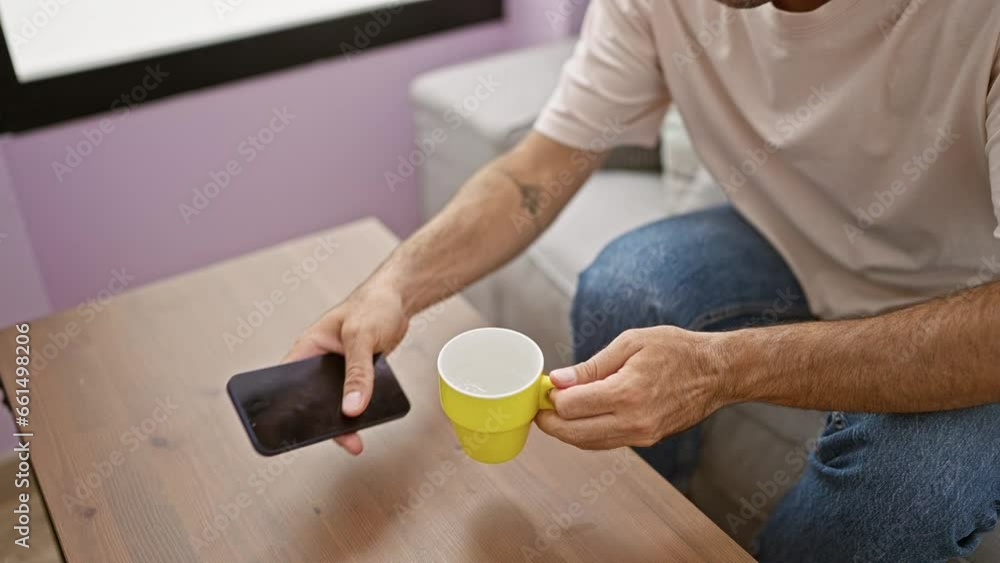 Young hispanic man using smartphone drinking coffee at home Young hispanic man using smartphone drinking coffee at home