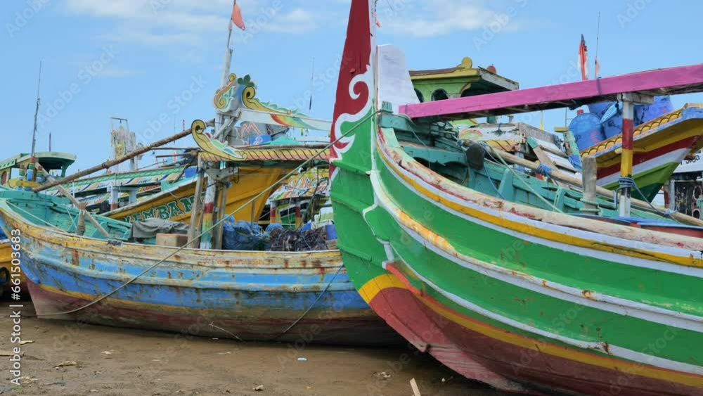 Wooden fishing boats are densely parked in a dry and dirty harbor on a hot afternoon on Indonesia's Java coast. Depicts the difficulty of traditional fishermen getting fish Wooden fishing boats are densely parked in a dry and dirty harbor on a hot afternoon on Indonesia's Java coast. Depicts the difficulty of traditional fishermen getting fish