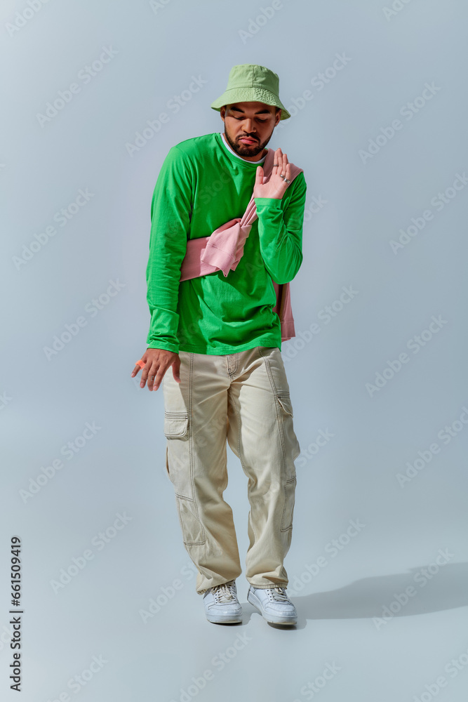 good looking young man with sweatshirt tied on his shoulders dancing on camera, fashion concept good looking young man with sweatshirt tied on his shoulders dancing on camera, fashion concept