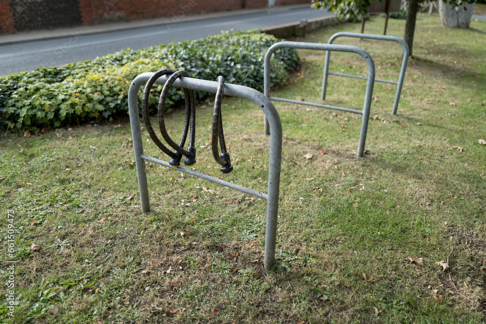 Trio of heavy duty bike chains seen attached to one of three metal bike racks located outside an English church. Trio of heavy duty bike chains seen attached to one of three metal bike racks located outside an English church.