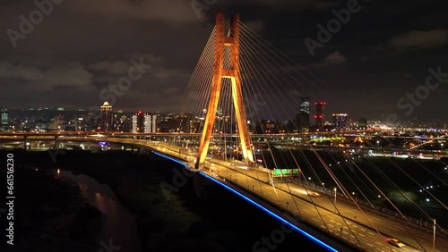 Aerial 4k video of Xinbei bridge at night. Cars passing through the bridge with colorful lights. New Taipei City, Xindian Sunshine Sports Park Sunshine Bridge. photo