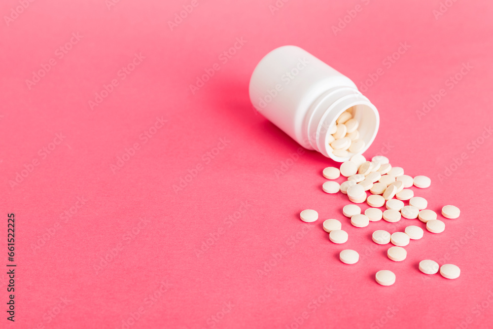 Medicine bottle and white pills spilled on a light background. Medicines and prescription pills flat lay background. White medical pills and tablets spilling out of a drug bottle Medicine bottle and white pills spilled on a light background. Medicines and prescription pills flat lay background. White medical pills and tablets spilling out of a drug bottle