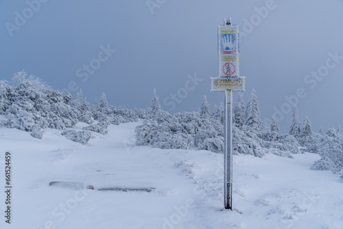 Tourist signpost and board information on trail from Szrenica Peak to Sniezne Kotly. Beautiful winter scenery. © Marcin