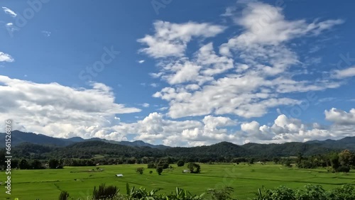 Time-lapse of beautiful blue sky with cloudy movement on green mountain. Puffy fluffy white clouds. Cumulus cloudscape time lapse.