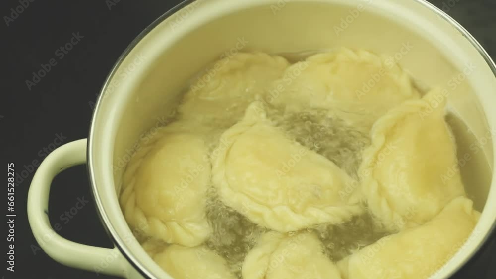 Dumplings are cooked in water, view from the mountain. Dumplings are cooked in a pot. Ukrainian national dish Dumplings are cooked in water, view from the mountain. Dumplings are cooked in a pot. Ukrainian national dish