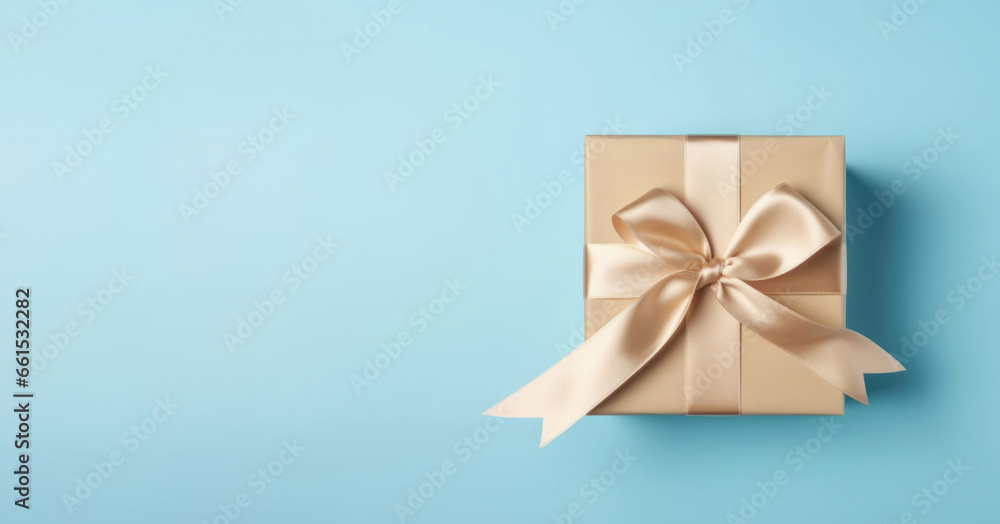 Christmas present with copy space. Gift box with golden satin ribbon and bow on blue background. AI generated Christmas present with copy space. Gift box with golden satin ribbon and bow on blue background. AI generated