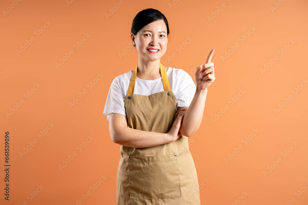 Portrait of Asian female housewife posing on brown background Portrait of Asian female housewife posing on brown background