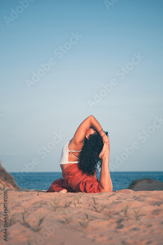 Young woman doing yoga pose on the beach