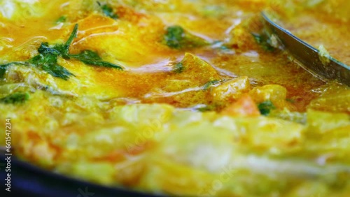 A close-up view of traditional Bahian moqueca, simmering in a rich blend of coconut milk and palm oil, showcasing the authentic flavors of Bahia, Brazil.  photo