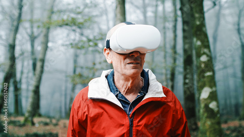 Elderly man is experienced the virtual reality in the nature into the forest