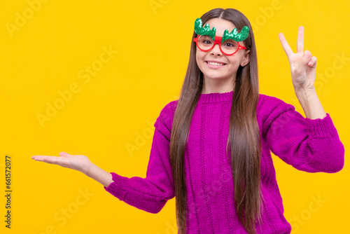 glad child having fun. kid with party glasses. teen girl presenting product