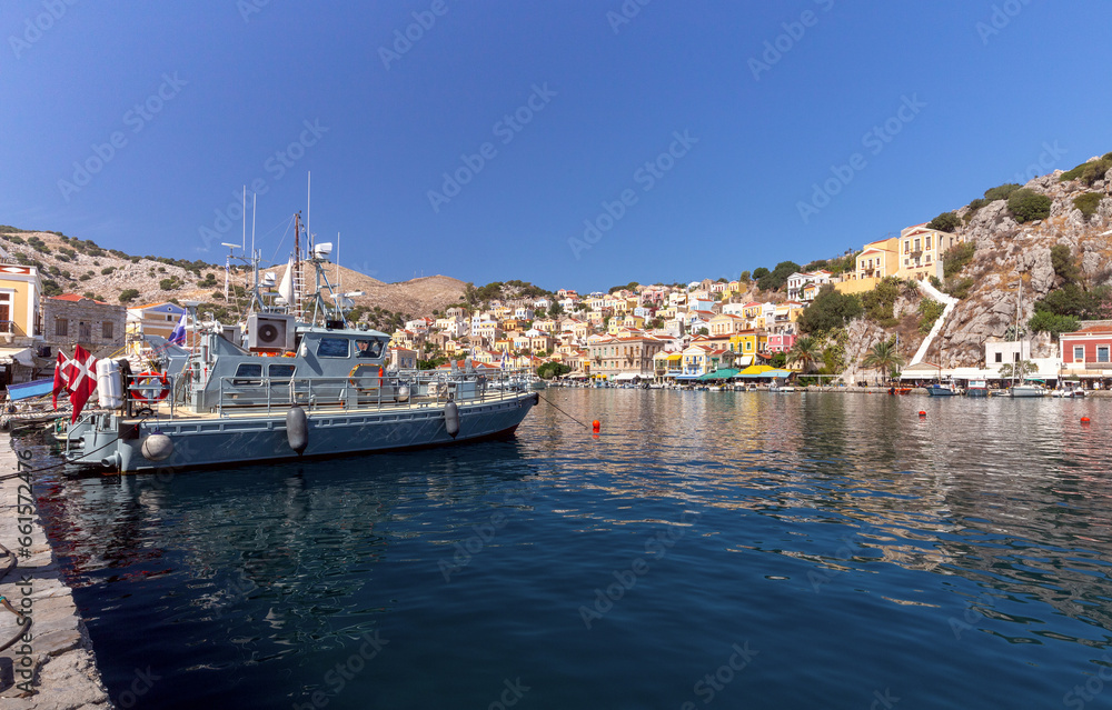 Colorful houses on the slopes of the mountains on the island of Symi on a bright sunny day.