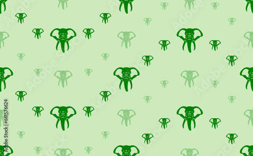 Seamless pattern of large and small green elephant heads. The elements are arranged in a wavy. Vector illustration on light green background