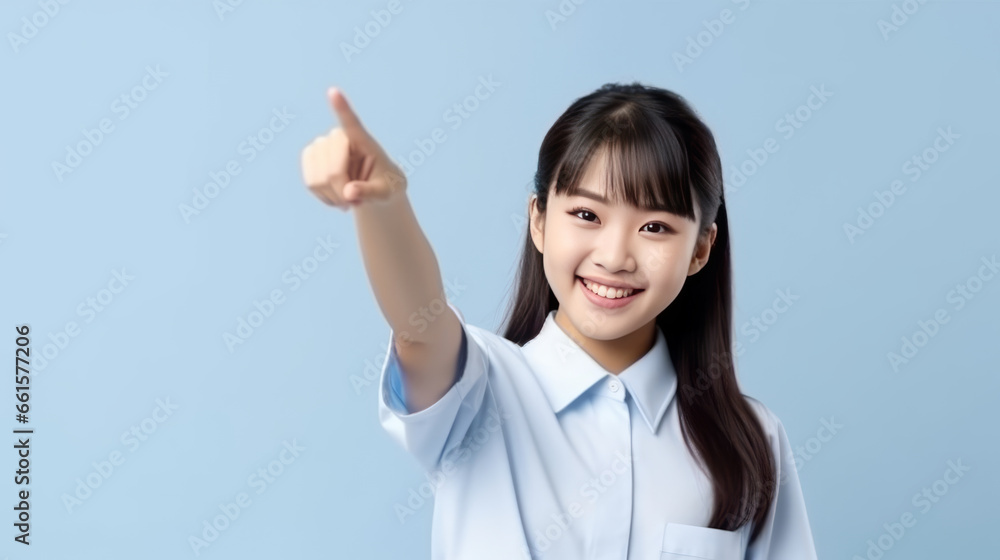 smiling of teen student girl of Asian ethnicity in university uniform pointing finger away. smiling of teen student girl of Asian ethnicity in university uniform pointing finger away.