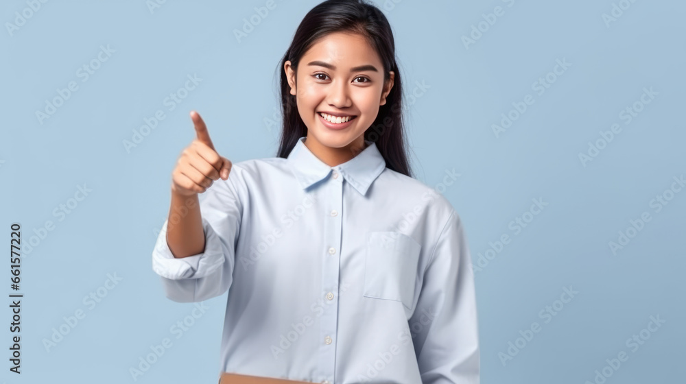 smiling of teen student girl of Asian ethnicity in university uniform pointing finger away. smiling of teen student girl of Asian ethnicity in university uniform pointing finger away.