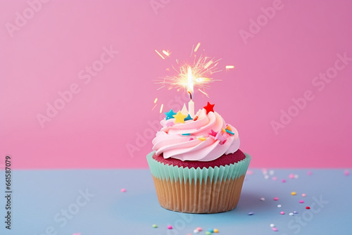 Birthday composition. Festive cupcake  multi - colored candles  metallic fringes on pastel pink paper. Flat lay  top view. Copy space. Banner backdrop