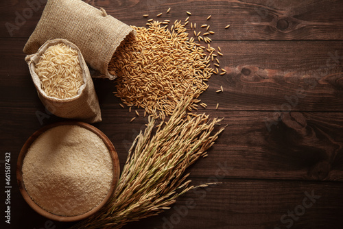 Top view of organic Rice (Oryza sativa) flour in a wooden bowl and raw stages of rice in a jute bag. photo