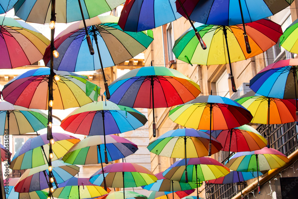 Bright colorful hundreds of umbrellas floating above the street