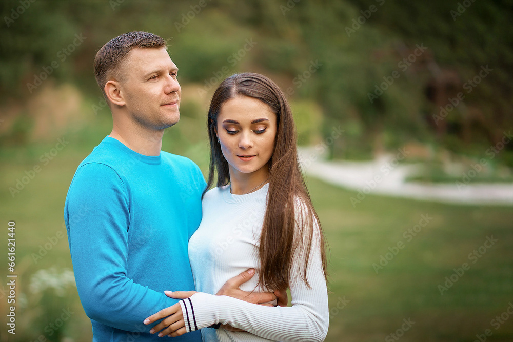 Portraine of smiling beautiful young couple hugging while standing on the nature Portraine of smiling beautiful young couple hugging while standing on the nature